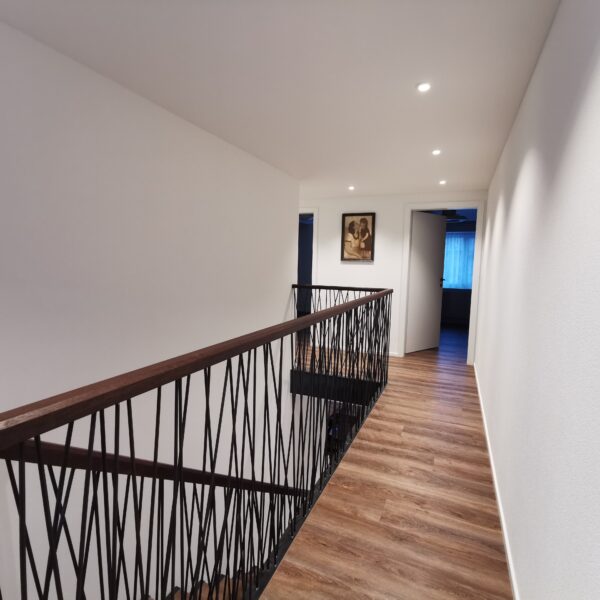 Gang mit kunstvollem Treppengeländer