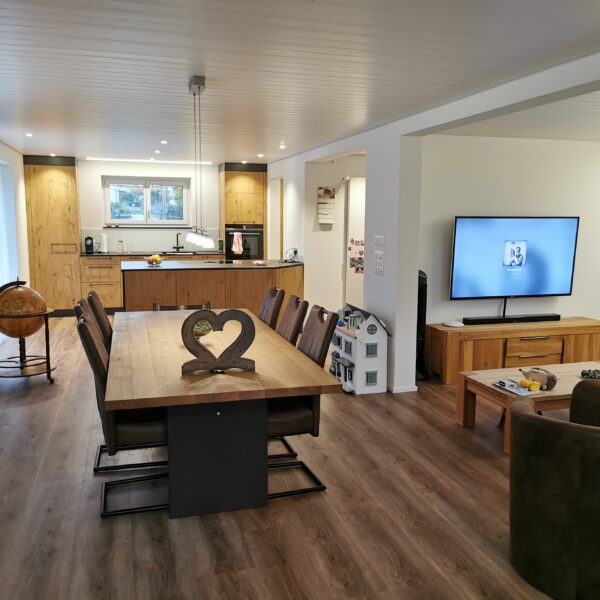 Wohnzimmer mit offener Küche in Holzoptik